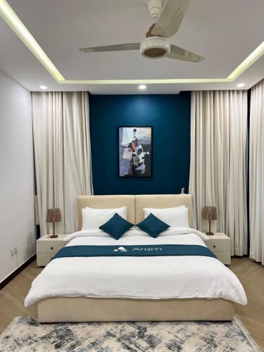 a bedroom with a large bed with blue walls at The SoHo in Islamabad