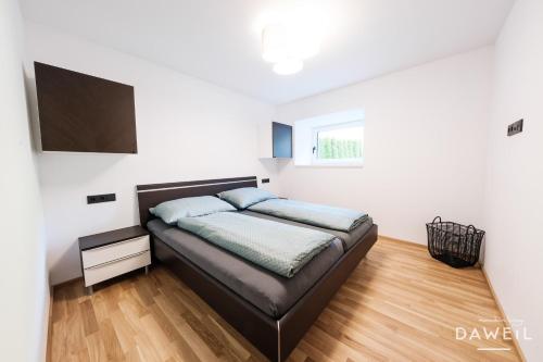 1 dormitorio con 1 cama en una habitación blanca en Daweil Mountain Living, en Matrei am Brenner