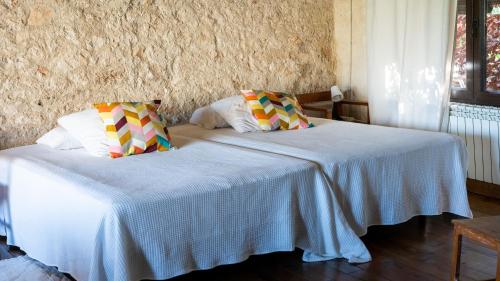 a bedroom with two beds with white sheets at Casa Rural La Chocolateria in Horche