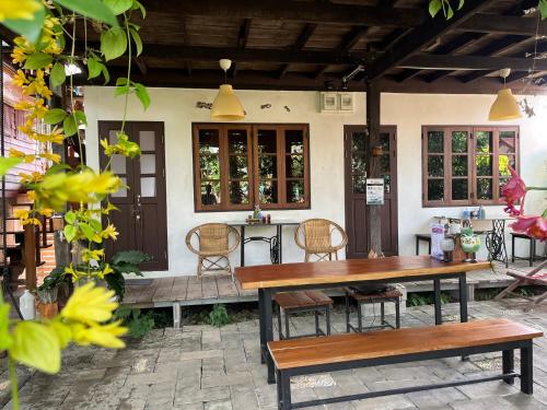 a patio with a wooden table and chairs at ครูหนูบ้านพัก แหลมงอบ Krunou baanpak in Trat