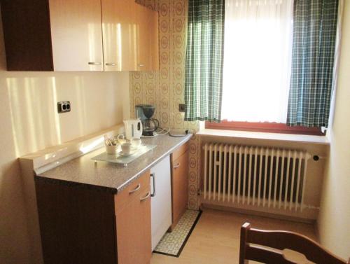 uma pequena cozinha com um balcão e uma janela em Lenche Gasthaus Neumayer 