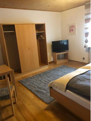 1 dormitorio con 1 cama y TV de pantalla plana en Lenche Gasthaus Neumayer, 