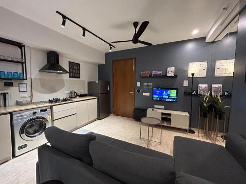 a living room with a couch and a tv at European studio apartment at Hiranandani thane in Thane