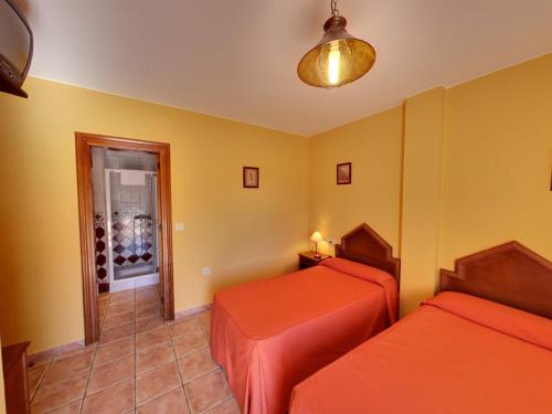 a room with two beds and a door to a wine cellar at Hotel Rural Pepe Alvarez in Trevélez