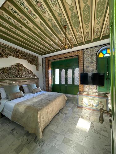 a bedroom with a large bed and a ceiling at Dar Waya in Mahdia