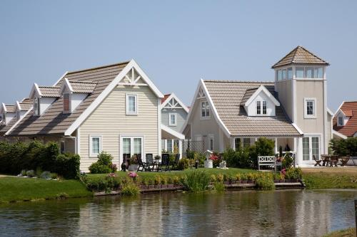 una fila de casas junto a un río en Summio Duynparc De Heeren van 's-Gravensande, en Vluchtenburg