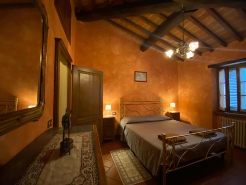 a bedroom with a bed in a room with orange walls at Casolare il Moro in Monte San Savino