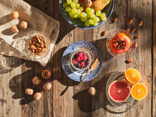 a wooden table topped with bowls of fruit and nuts at HOTEL StDaniel in Štanjel