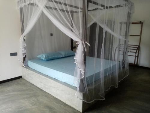 a bedroom with a bed with a canopy at Villa Conch by Om - Private House - Hikkaduwa in Hikkaduwa
