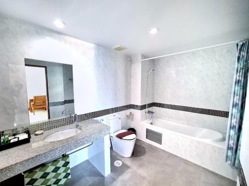uma casa de banho com um lavatório, uma banheira e um WC. em Nanthana Villa em North Pattaya