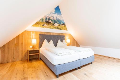 a bedroom with a bed with a painting on the wall at Vitalhof am Kreischberg by ALPS RESORTS in Bodendorf