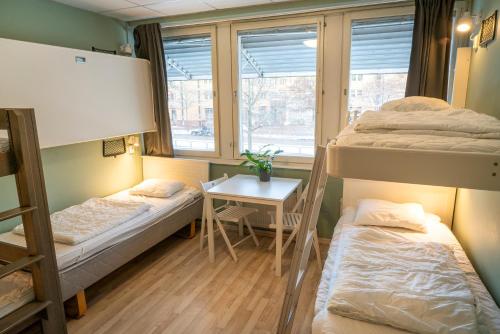 a dorm room with two bunk beds and a table at Göteborg Hostel in Gothenburg