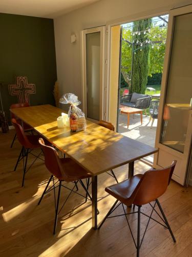 a wooden table in a living room with chairs at Villa proche d'Avignon. in Le Pontet