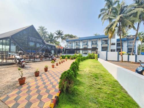 a resort with a pathway with plants and a building at The Upper House resort by J R high Sky in Morjim