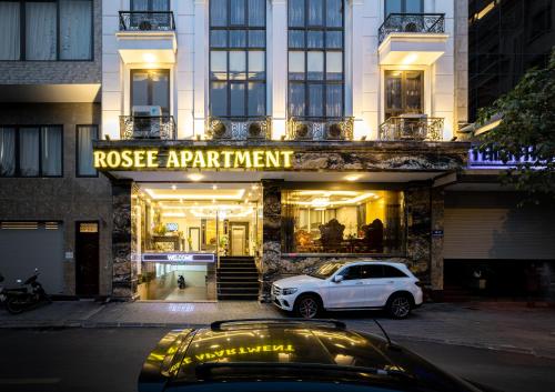 Rosee Apartment Hotel - Luxury Apartments in Cau Giay , Ha Noi في هانوي: سيارة بيضاء متوقفة أمام مبنى