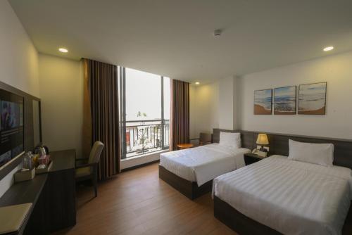 a hotel room with two beds and a large window at Chiic House 5 - Khách sạn tình yêu in Nha Trang