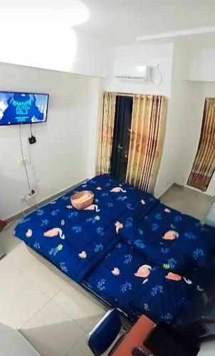 a bed with a blue comforter with fish on it at Sleepwell in Tambun-lobangbuaja