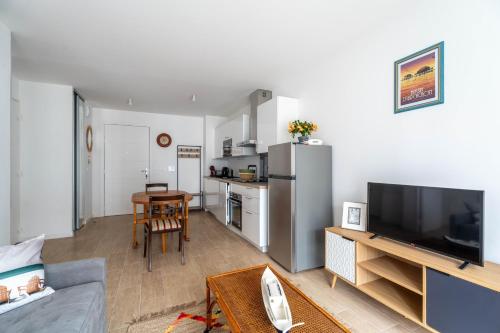 - un salon avec un réfrigérateur et une table dans l'établissement CHARMANT APPARTEMENT CENTRE VILLE, à Arcachon