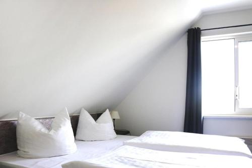 een slaapkamer met 2 bedden met witte kussens en een raam bij Holiday Resort Van der Valk, Linstow in Linstow