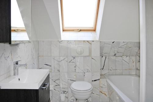 een badkamer met een toilet, een wastafel en een bad bij Holiday Resort Van der Valk, Linstow in Linstow