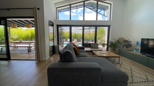 un salon avec un canapé gris et une table dans l'établissement Villa Arcachonnaise, à Andernos-les-Bains