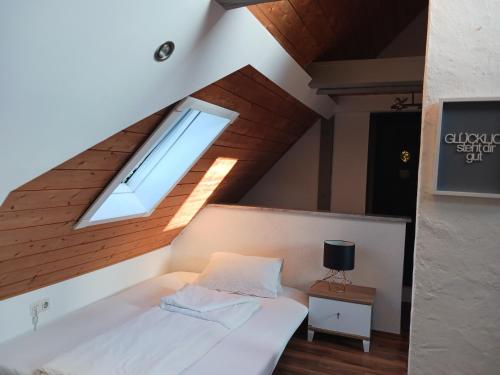 een zolderkamer met een bed en een raam bij Stadt Hotel Marktheidenfeld in Marktheidenfeld