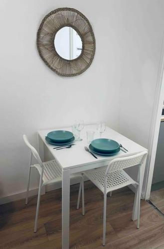 une table blanche avec deux plaques bleues et un miroir dans l'établissement Le P'tit Stud', à Castres