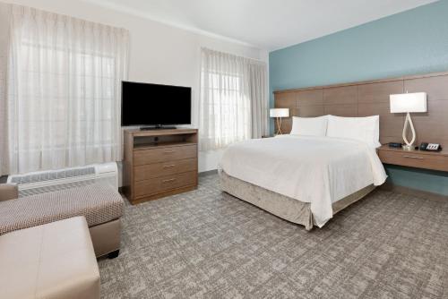 ein Hotelzimmer mit einem Bett und einem Flachbild-TV in der Unterkunft Staybridge Suites - San Antonio - Schertz, an IHG Hotel in Schertz