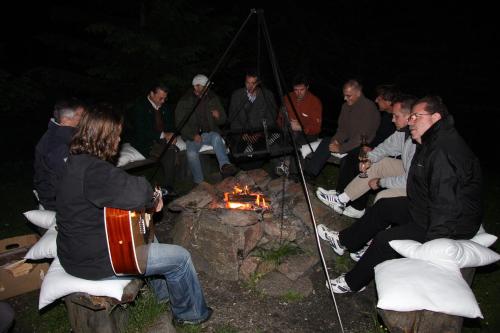 a group of people sitting around a campfire at night at Bischofhütten in Bad Sankt Leonhard im Lavanttal