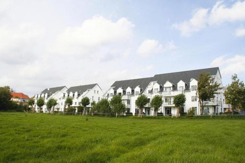 a row of white houses on a green field at Apartment in Boltenhagen near the sea in Boltenhagen