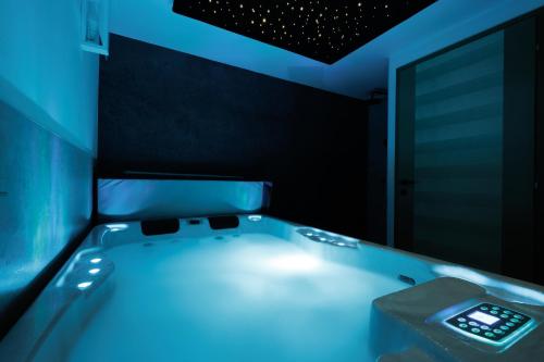 a bath tub with blue lighting in a room at Franc Holiday House With a Spacious Terrace, Hot Tub And Sauna in Lopatinec