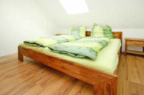 a wooden bed with pillows on it in a room at Ferienhof Mirow, Mirow in Mirow