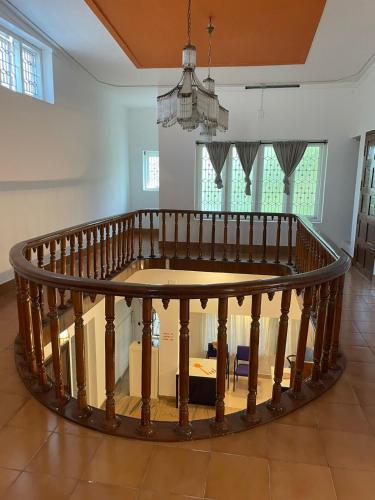 a round wooden table in a room with a staircase at Flyon HomeStay in Kannur