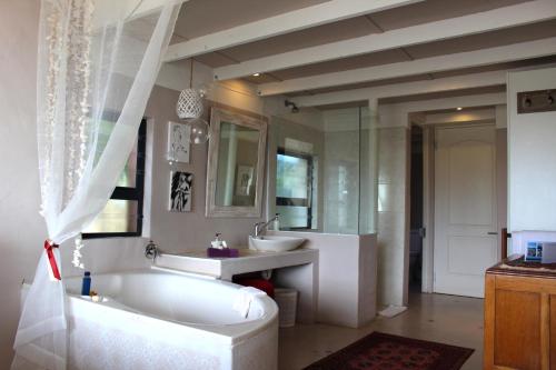 a white bathroom with a tub and a sink at Absolute Beach Accommodation in Stompneusbaai