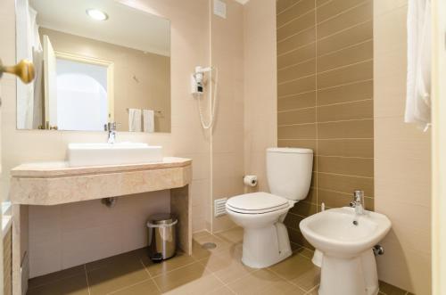 a bathroom with a toilet and a sink at Alfagar Village in Albufeira