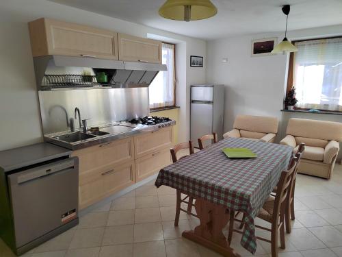 a kitchen with a table and a kitchen with a sink and a stove at Chalet Migazzi in Cogolo