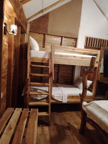 a room with two bunk beds in a cabin at LAMIACEAE WOOD CABIN in Ella