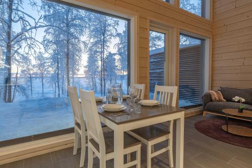 una sala da pranzo con tavolo, sedie e una grande finestra di Miilu Resort a Ylläsjärvi