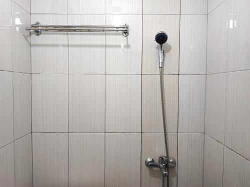 ein Bad mit einer Dusche und einem Telefon an der Wand in der Unterkunft RedDoorz Syariah near Universitas Batanghari Jambi in Jambi