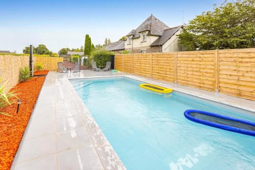 - une piscine dans un jardin avec une clôture en bois dans l'établissement La Fleur de Vie - Maison avec piscine et jacuzzi, à Paimpont