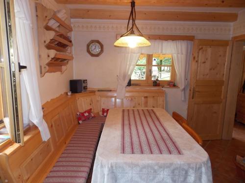 Zimmer mit einem Tisch und einer Uhr an der Wand in der Unterkunft Holiday House Kaja in Mojstrana