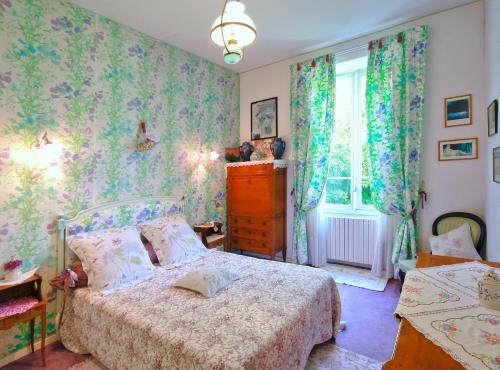 a bedroom with a bed and a window at Au Relais Fleuri in Gilette