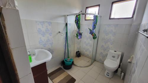 uma casa de banho com um chuveiro, um WC e um lavatório. em Different Strokes Cottage em Diani Beach