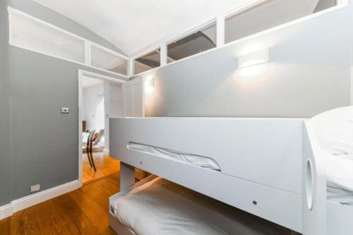 a white bedroom with a bed and a desk at 2 Bed Flat South Kensington in London