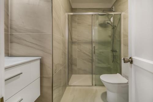 a bathroom with a shower and a toilet at Bright Amadores Seaview Apartment in Puerto Rico de Gran Canaria