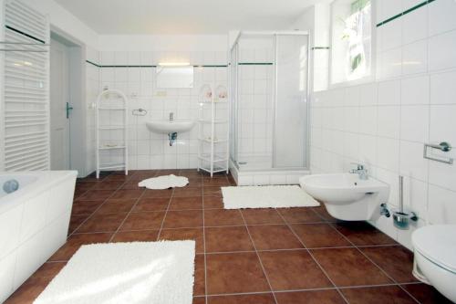 a bathroom with a tub and a sink and a toilet at Holiday home Rosenhof, Lenzen in Lenzen