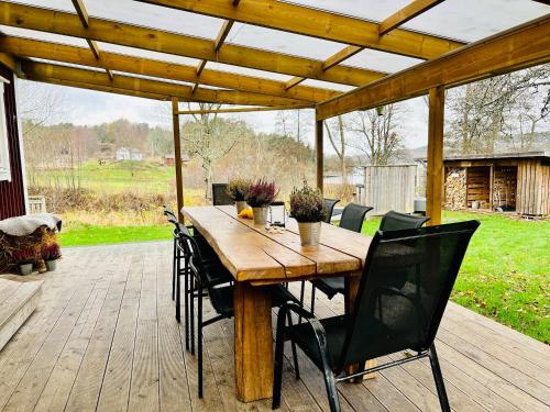 una mesa de madera y sillas en una terraza de madera en Cozy cottage with sea view, en Svenshögen