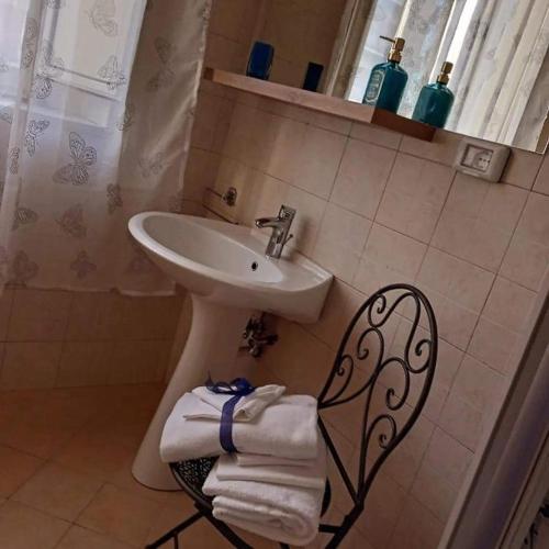 a bathroom with a sink and a chair with towels at Il Principe di Napoli in Benevento