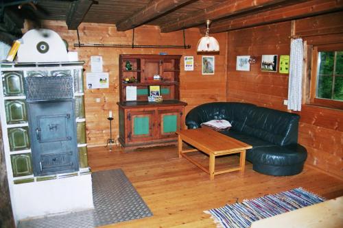a living room with a leather couch and a table at Bischofhütten in Bad Sankt Leonhard im Lavanttal