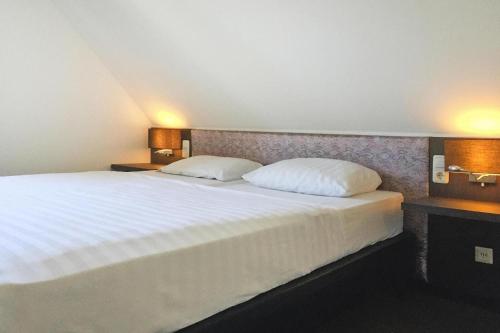 a bedroom with a large bed with two pillows at Holiday Resort Van der Valk, Linstow in Linstow